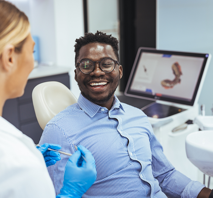 Man smiling at his dentist before receiving dental services in Brenham