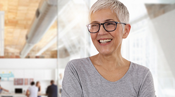 Smiling woman with short gray hair an a gray shirt